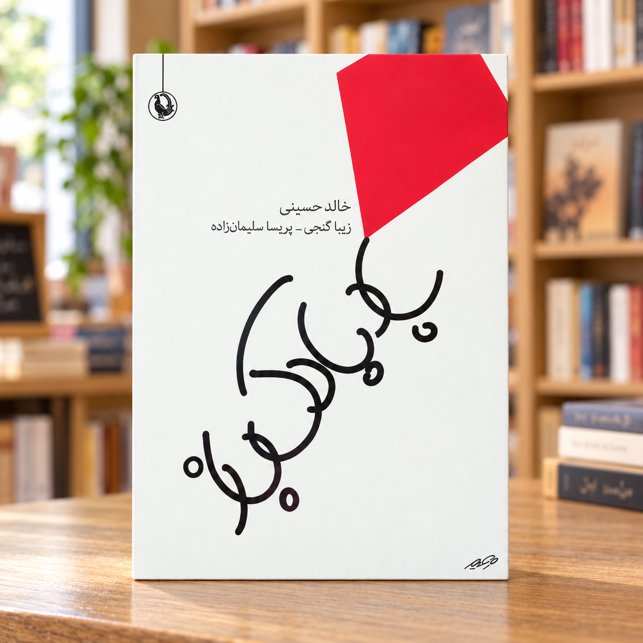 بادبادکباز — خالد حسینی — نمای روبهروی کتاب در کتابفروشی جلد کتاب بادبادکباز اثر خالد حسینی، ترجمه زیبا گنجی و پریسا سلیمانزاده، نشر مروارید، در پسزمینه کتابفروشی